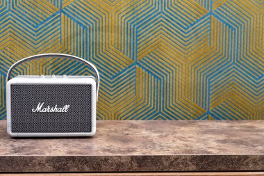  Müzik severler için modern Marshall taşınabilir ses sistemi bir şifonyerin üzerinde duruyor.