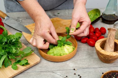 Avokado soyulmuş ve aşçının elinde çıkarılmış bir çukur. Avokado servise hazır..