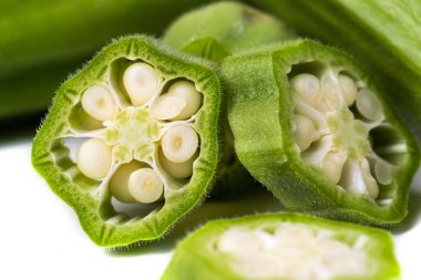 Green fresh okra. Pieces on a white background. macro photography. clipart