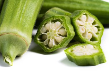 Yeşil taze bamya. Beyaz arka plandaki parçalar. makro fotoğrafçılık.