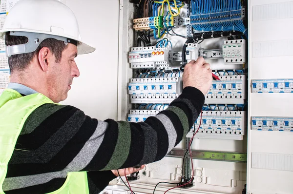 Electrician checking a fuse box Stock Photo