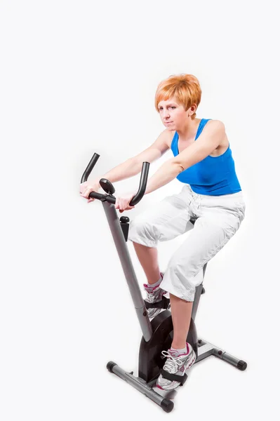 Kvinnan gör sport på motionscykel — Stockfoto