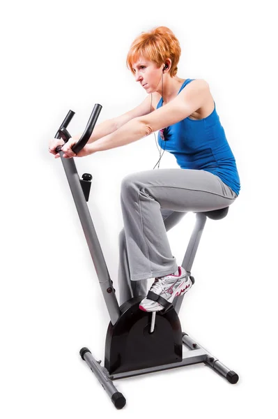 Woman doing sports on exercise bike — Stock Photo, Image