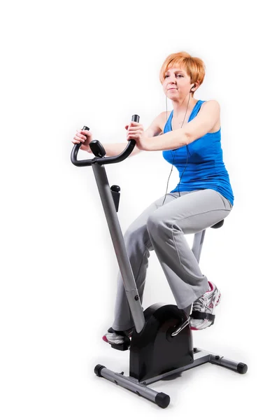 Mulher fazendo esportes em bicicleta de exercício — Fotografia de Stock