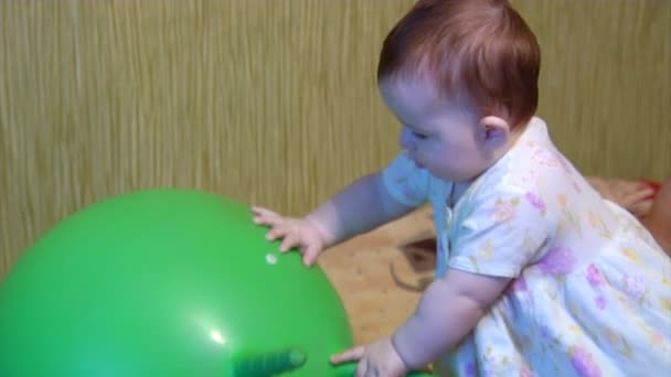 Baby spielt mit grünem Ball — Stockvideo