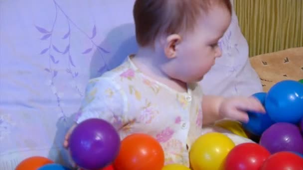 Baby spielt mit Plastikbällen — Stockvideo