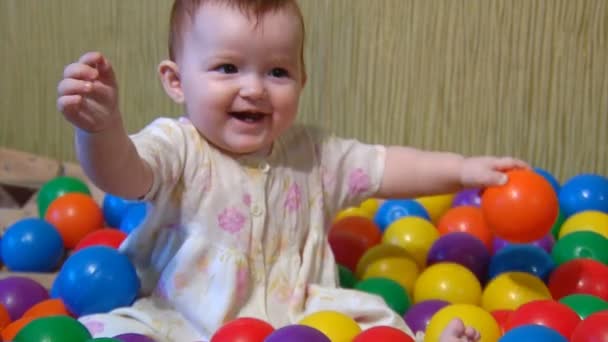 Baby spela med plast bollar — Stockvideo