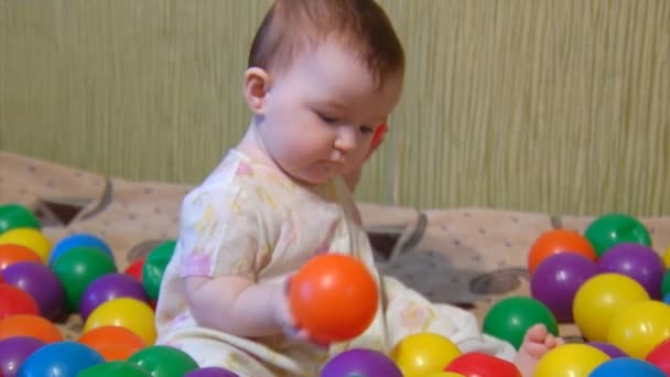 Baby spela med plast bollar — Stockvideo