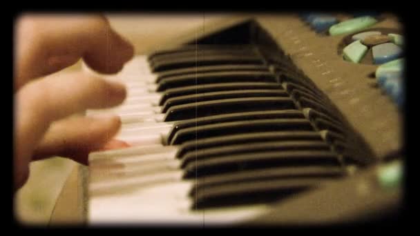 Criança joga no piano de brinquedo como filme de carretel — Vídeo de Stock