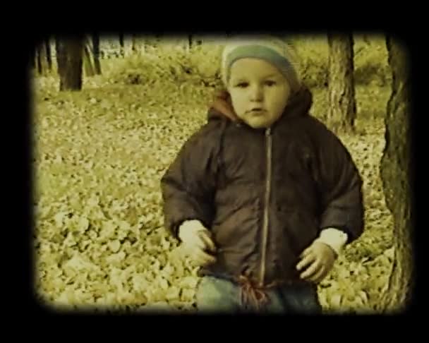 Kleines Baby spielt im herbstlichen Park — Stockvideo