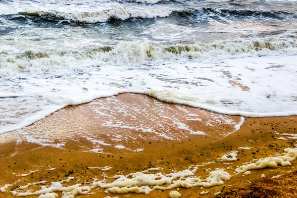 沿着沙滩的沙滩爬行的泡沫的特写 — 图库照片
