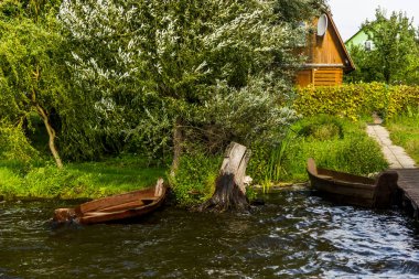 Gölün kıyısındaki çimlerin üzerinde eski ahşap bir tekne