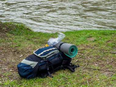Nehir kıyısında duran büyük bir sırt çantasının yakın çekimi.