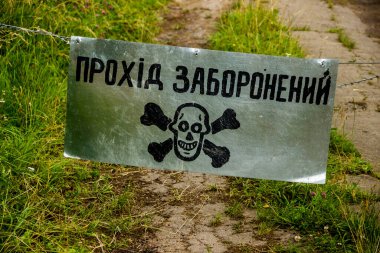close-up of a no entry sign with jolly skull and bones on the road. Text translated from ukrainian as 'no entry'