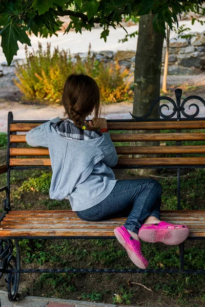 Little Girl Sitting Bench Turned Her Back Looks Distance — Stock fotografie