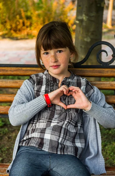 Happy Little Caucassian Girl Sitting Bench Make Handly Sign Heart — стоковое фото