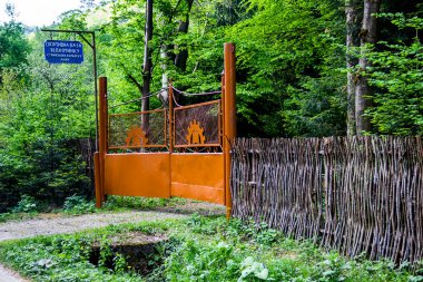 Ukrayna 'nın Lviv bölgesindeki Skole Beskids Ulusal Doğa Parkı, Karpatya' daki turist kampının demir kapısı ve ahşap sazdan çiti. Metin 'Stryi Profesyonel Lviv Ulusal Çevre Üniversitesi Spor Rekreasyon Merkezi' olarak çevrildi.