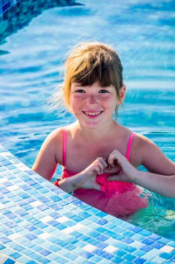 Mavi mozaikli küçük bir kız yüzme havuzunda