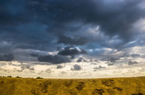 a blue stormy cloudy sky under the yellow sand of sea beach,  Arabat Spit, Ukraine