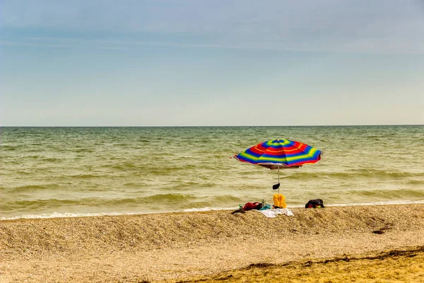 striped beach umbrella on the Sea of Azov beach, Ukraine