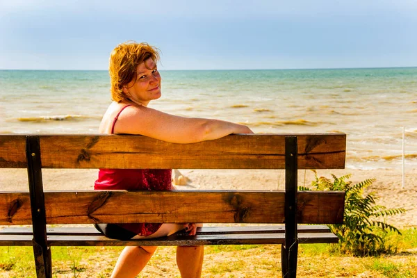 Woman Sitting Bench Front Seashore Looking Camera — Stock Photo, Image