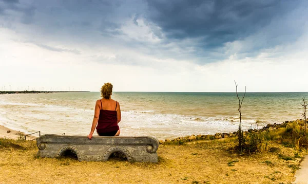 Kvinna Som Sitter Bänken Framför Stranden Och Tittar Havet — Stockfoto