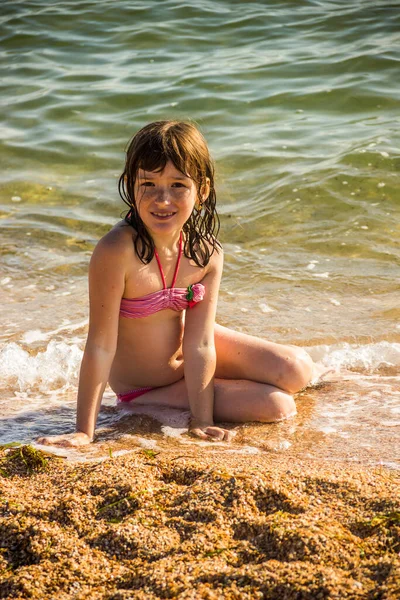 海水浴場の赤い水着の少女が — ストック写真