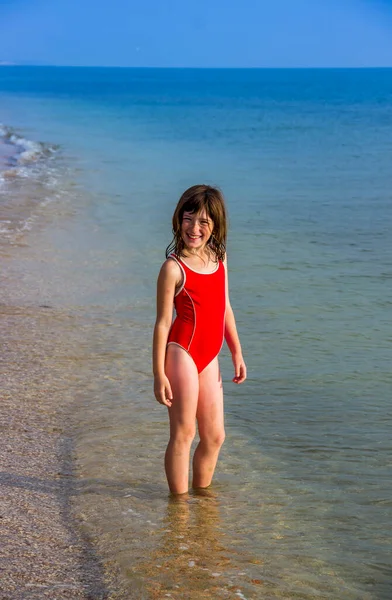 在海滩上穿着红色游泳衣的小女孩 — 图库照片