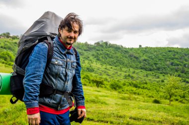 a tourist man with big backpack in the forest at hiking