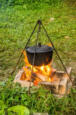 Kamp ateşindeki siyah kazanın yakın çekimi.