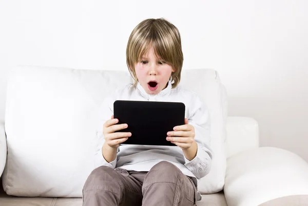 Surprised blonde boy with tablet — Stock Photo, Image