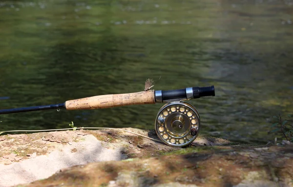 Flyfishing rod on the stone by the river Stock Photo