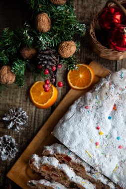 Ahşap arka planda çalınmış geleneksel noeller. Alman Xmas meyveli keki. Üst görünüm