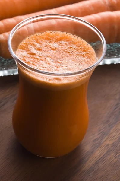 Carrot juice on a wooden background — Stock Photo, Image