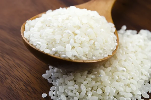 Reis in Holzlöffel auf Küchentisch — Stockfoto