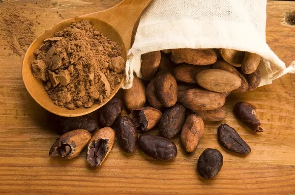 Какао (какао) боби на натуральному дерев'яному столі — стокове фото
