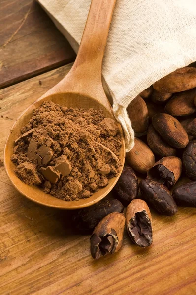 Cocoa (cacao) beans on natural wooden table — Stock Photo, Image