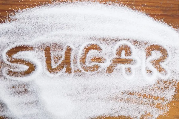 Beyaz toz şeker yığınına yazılı kelime şeker — Stok fotoğraf