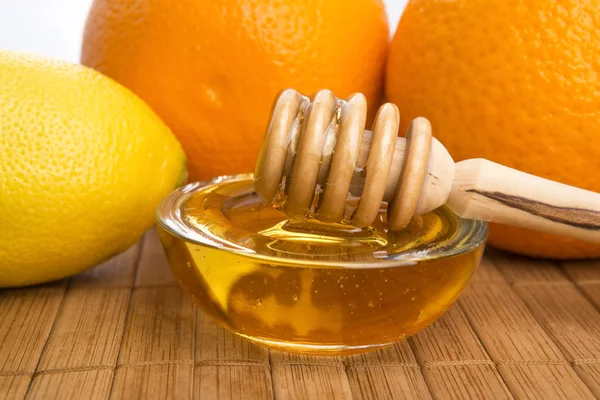Свежий мед с лимоном и апельсинами — стоковое фото