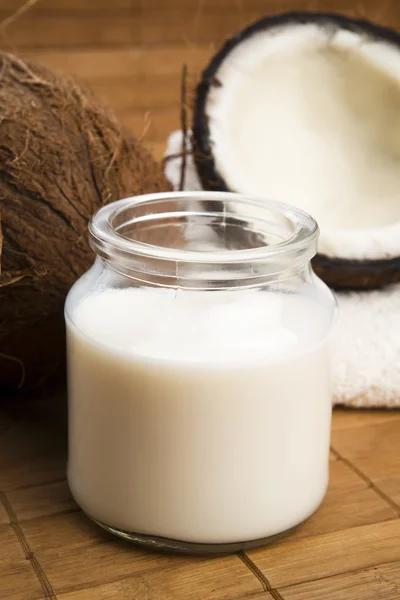 Coconut fruit with a jar filled with coco milk — Stock Photo, Image
