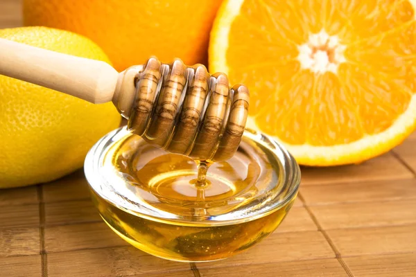 Verse honing met citroen en oranje vruchten — Stockfoto