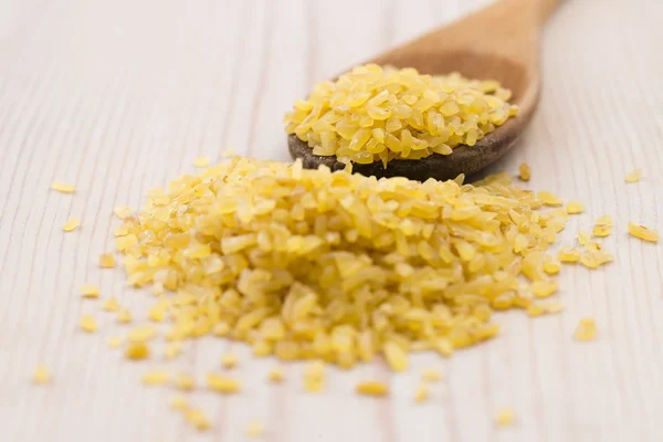 Trigo bulgur en cuchara de madera — Foto de Stock