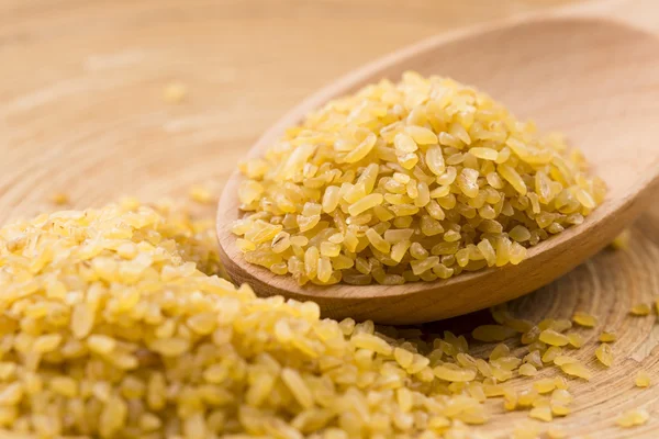 Trigo bulgur en cuchara de madera —  Fotos de Stock