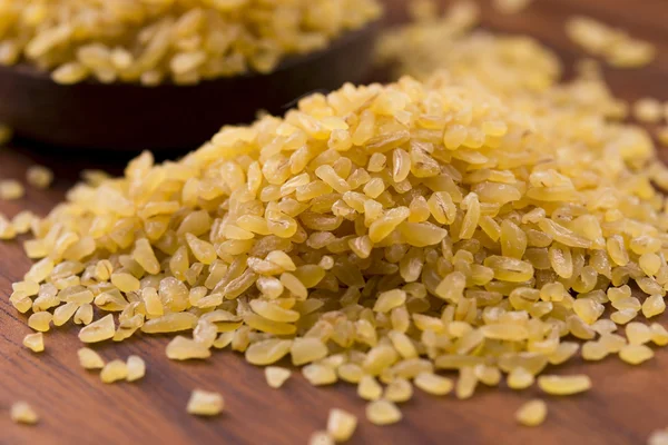 Trigo bulgur en cuchara de madera —  Fotos de Stock