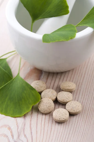 Ginkgo biloba leaves in mortar and pills — Stock Photo, Image