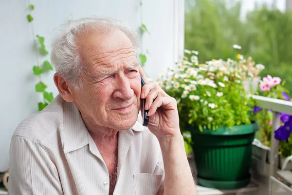 Грустный пожилой человек с телефоном — стоковое фото