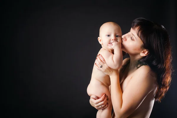 Mutter küsst ihr Baby auf schwarzem Hintergrund — Stockfoto