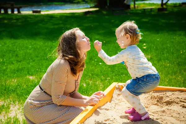 Mother and daughter blowing soup bubbles — Stock Photo, Image