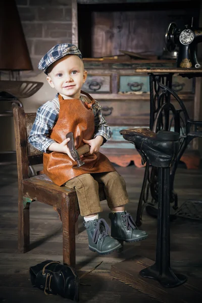 Liten pojke med hammare imitera skomakare — Stockfoto