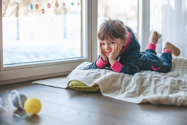Усміхнена Дівчинка Лежить Вовняній Ковдрі Біля Вікна Надворі Сніг Холод — стокове фото